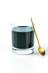 Spirulina drink in a glass with a spoon on a white background.
