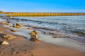 breakwater and beach in the first rays of sun, Baltic Sea in Poland