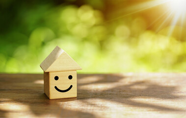 House model and wooden cubes with smile icon on natural background.                      