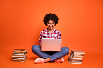 Full body portrait of positive clever person use wireless netbook typing email isolated on orange color background