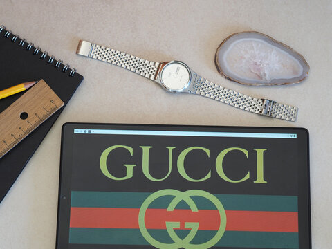 In this photo illustration Gucci logo seen displayed on a tablet