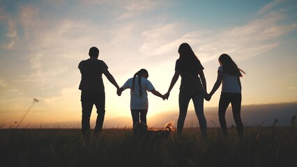 Fototapeta na wymiar people in the park. silhouette of a big happy family on a walk with a dog at sunset in a field in nature. happy family kid dream concept. big friendly family walks at sunset in the park lifestyle
