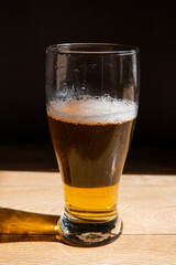 beer in a glass near a green bottle and on a black background