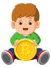The little boy is sitting and playing with the one big bitcoin