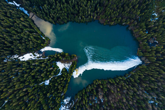 Synevyr lake in the Carpathians, top view of the lake, mountain lake covered with ice, ice line on Synevyr lake.