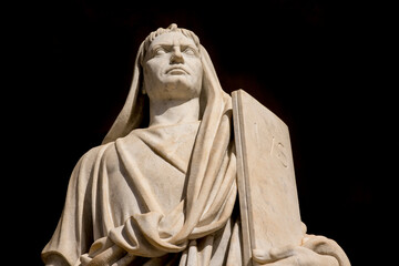 Closeup of a travertine marble statue on a black background