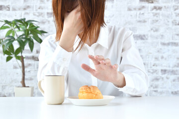 Obraz na płótnie Canvas ダイエットイメージ―スイーツを食べるかどうかを葛藤する女性