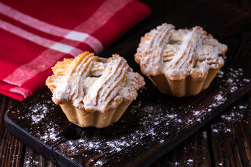 A cup of black tea and a plate with homemade bakery, biscuit on a wooden table. Close-up.