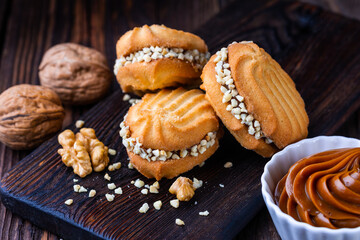 A cup of black tea and a plate with homemade bakery, biscuit on a wooden table. Close-up.