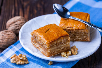 A cup of black tea and a plate with homemade bakery, biscuit on a wooden table. Close-up.
