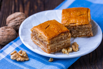 A cup of black tea and a plate with homemade bakery, biscuit on a wooden table. Close-up.