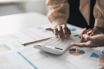 Fototapeta premium Close up Businessman and partner using calculator and laptop for calaulating finance, tax, accounting, statistics and analytic research concept