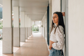 portrait of latin american woman standing leaning against wall