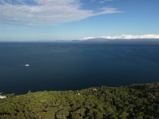 Fototapeta premium Aerial panoramic view of seascape with crystal clear azure sea. Yachts in a beautiful lagoon on backdrop of rocks. The concept of an ideal destination for summer travel and vacation.