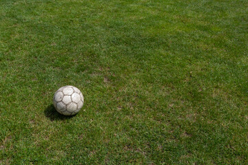 Soccer ball on green grass of football field with copy space