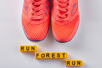 Pair of red sneakers with run forest run words. Isolated on white.