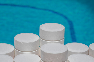 Pool maintenance with chemical chlorine tablets to disinfect pool water. Round chlorine tablets...