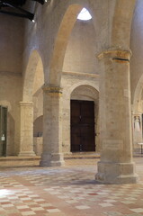 Fototapeta na wymiar Santa Maria di Collemaggio Basilica Interior Detail with Floor, Columns and Wooden Door in L'Aquila, Abruzzo, Italy