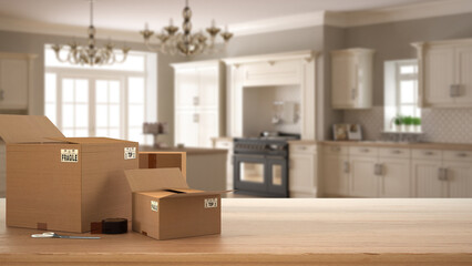 Wooden table, desk or shelf with stack of cardboard boxes over blurred view of vintage kitchen with cabinets, classic interior design, moving house concept with copy space