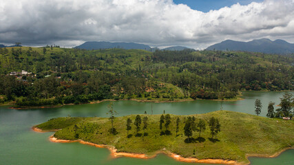 Fototapeta na wymiar Hills with tea plantations around the lake in the mountains. Maskeliya, Castlereigh, Sri Lanka.