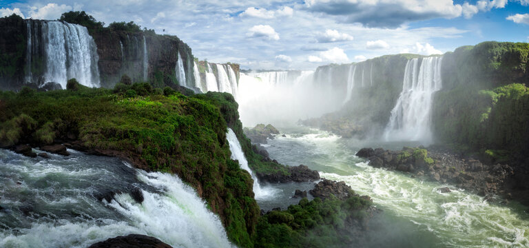 Amazing scenery of scenic waterfalls falling into fast river in sunlight
