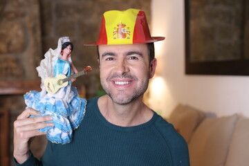 Patriotic Spanish man holding typical flamenco dancer doll with a guitar