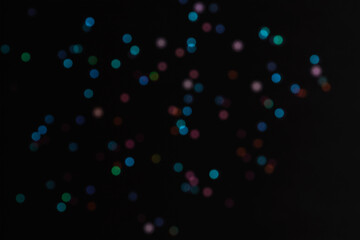 Black abstract bokeh festive background, texture. Colorful lights on black