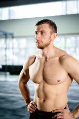 Athletic man posing hardcore in the gym