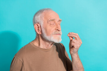 Portrait of attractive cheery dreamy grey-haired man pretending tasting good food isolated over bright blue color background