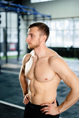 Obraz premium Athletic man posing hardcore in the gym