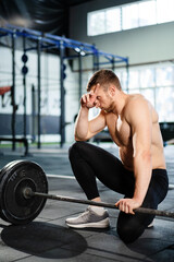 Naklejka premium Male athlete tired after jogging on a treadmill, resting after sports