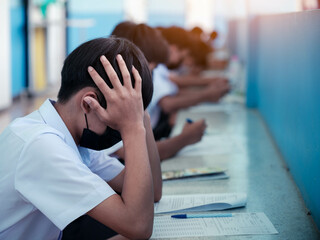 Students taking exam with headache and stress