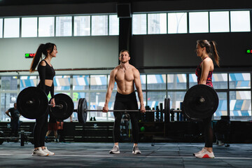 Athletes man and female Does Deadlift and Curls with a Heavy Barbell. Athletic Shirtless Man...