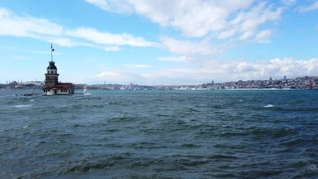 Maiden's Tower. Maiden's Tower or Kiz Kulesi with cityscape of Istanbul with windy weather and wavy sea. Panning shot from left to right.