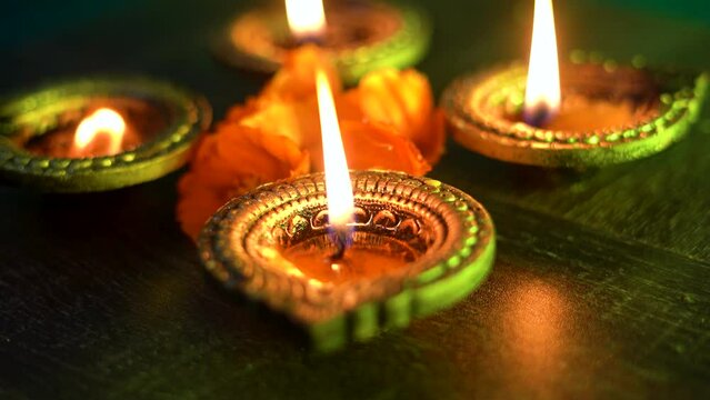 Colorful Diwali oil lamps, Deepavali oil lamps lighted in beautiful formation with flowers in middle. Oil lamps with sparkler. Motion of igniting hand held sparkler crackers