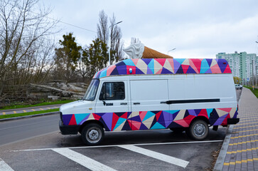 Bright, colorful car with a big ice cream on the roof.