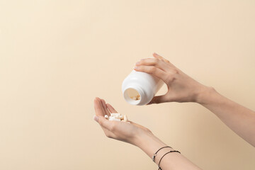 Female spilling over white pills or vitamins