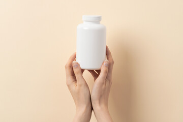 Femal hand holds a bottle of medication pills