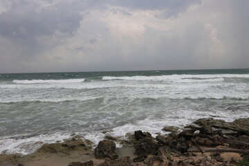 Fototapeta na wymiar Beautiful sea waves impact rocky coast on the beach