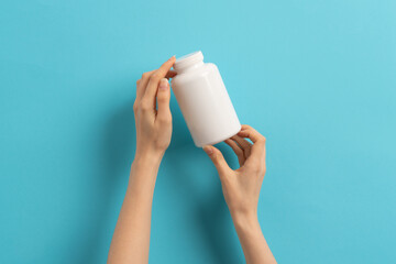 Female hand holding bottle of medication pills
