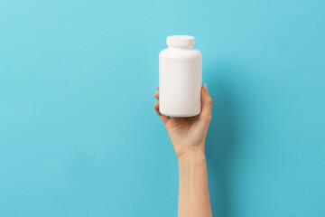 Female hand holding bottle of medication pills