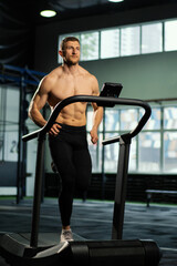 Naklejka na ściany i meble Male athlete running on a treadmill