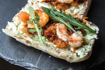 Bruschetta with shrimp sauce, sun-dried tomato and arugula
