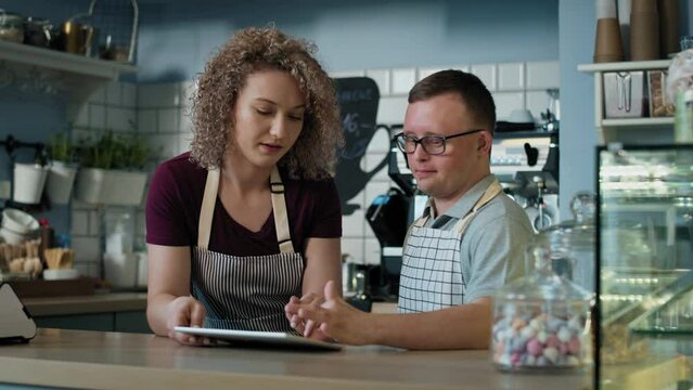 Caucasian man with down syndrome learning how to take orders on digital tablet. Shot with RED helium camera in 8K. 