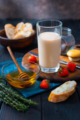 Village breakfast. A glass of milk, bread and fruit are on the table near the window in the rustic house.