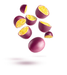 Passion fruit. Pieces of flying fruit. Purple fruits with yellow seeds flying in the air isolated on white background.
