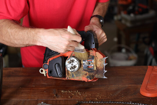 cleaning of the small chainsaw by a person