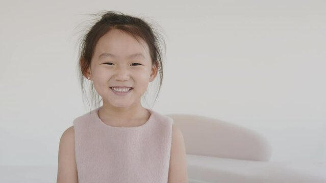 Portrait of a cute Asian baby girl looking straight into the camera, smiling and portraying happiness