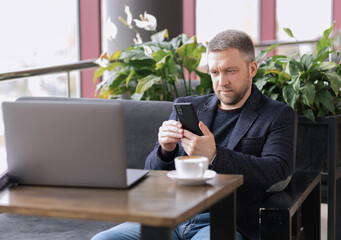 adult successful man in cafe parting on laptop