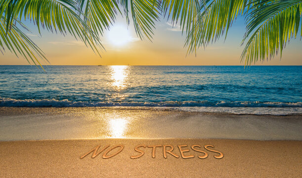 No stress concept with tropical beach and written text in the sand.